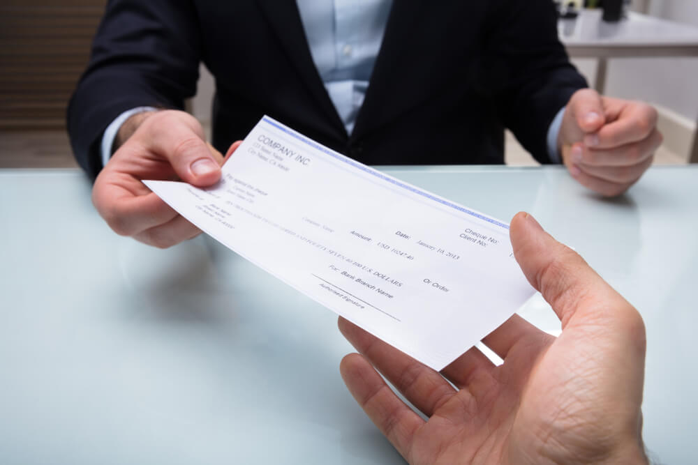 Close-up Of A Businessman's Hand Giving Cheque