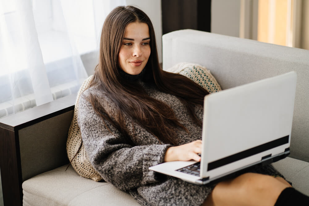 Young Woman Using Laptop at Cozy Living Room.